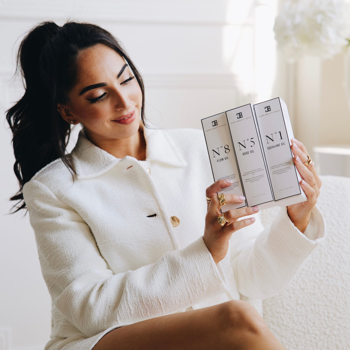 Woman holding the Inner Beauty Oil set boxes