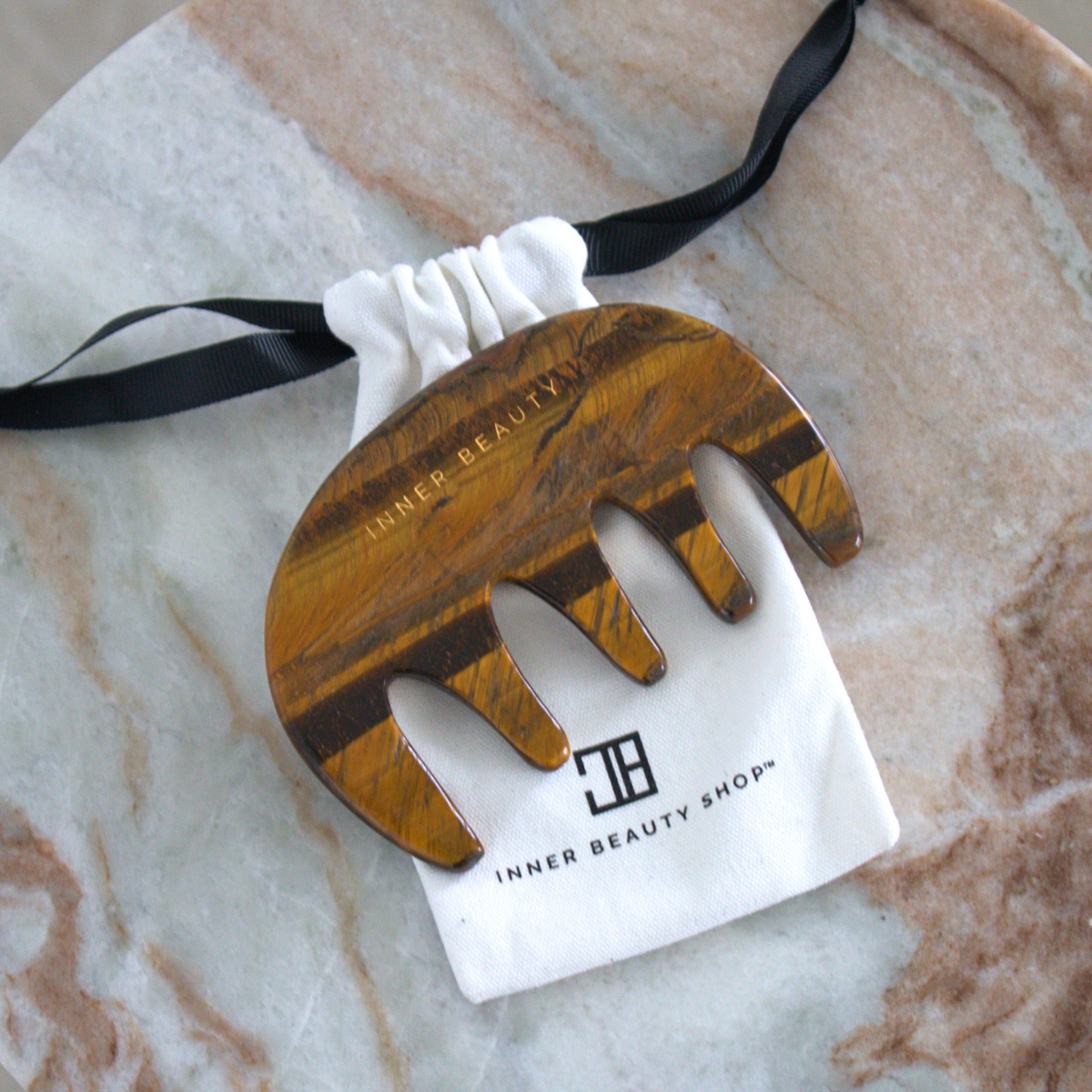 Tiger's eye gua sha comb with its cotton drawstring pouch
