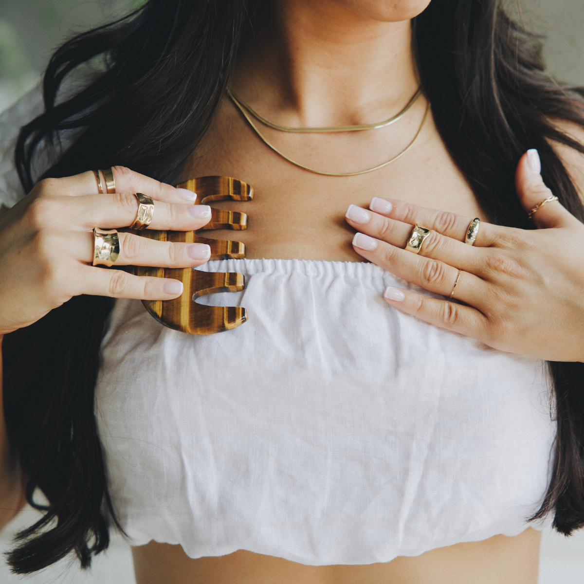 Tiger's eye gua sha comb used across the chest