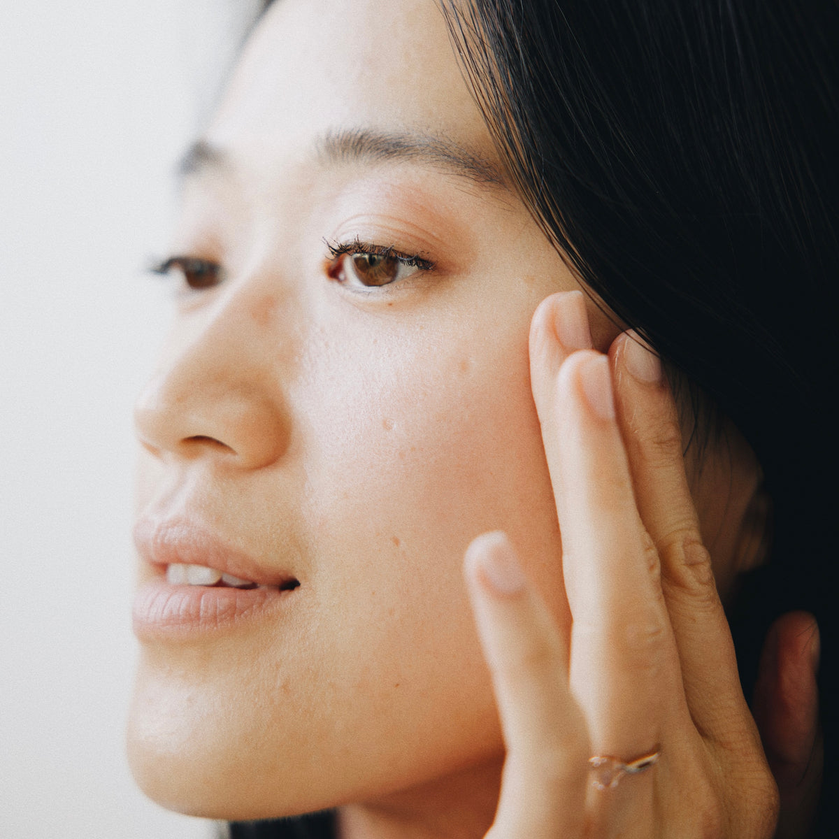 Woman pressing N°8 Flow Oil into her skin