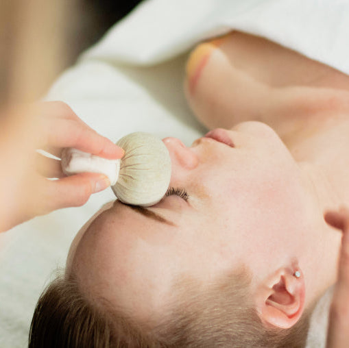 Thai herbal poultice used on the brow during a facial